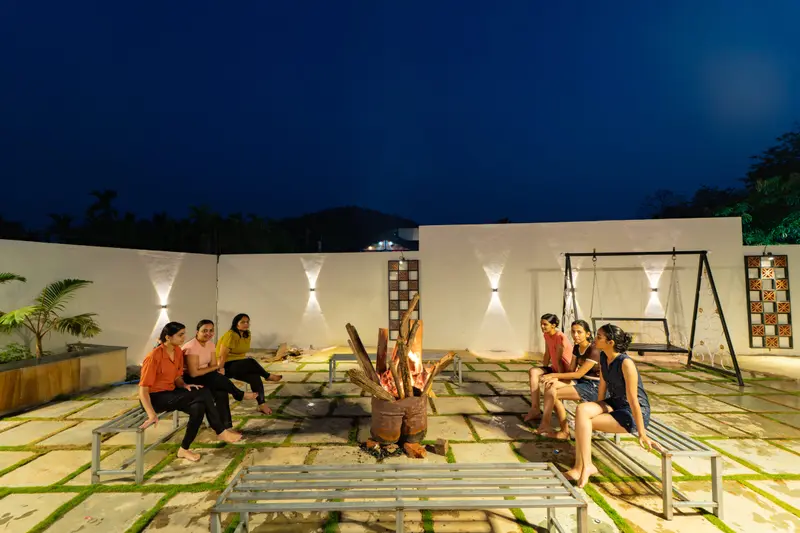 Guests relaxing in the lit courtyard at night
